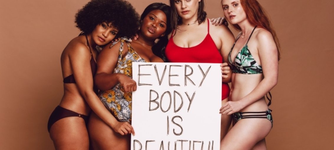 Mujeres con diferentes tipos de cuerpo más letrero "every body is beautiful"