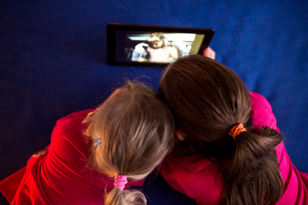 Entretenimiento infantil, niñas usando una tableta.